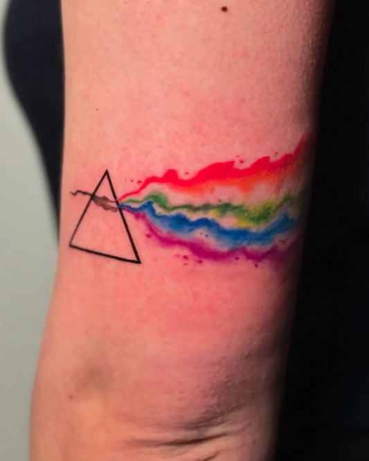 Small Pink Floyd Watercolor Prism Spectrum Music Tattoo on Women Arm by @ieiaccia_tattooer