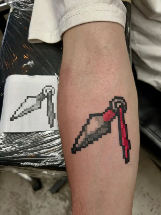 Small Pixel Art Kunai Knife Tattoo on Men Leg by @_buena.vida.tattoo