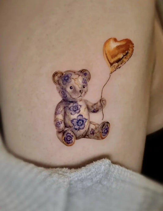 Small Porcelain Bear with Heart Balloon on Women Arm Tattoo by @fearlessme_tattoo