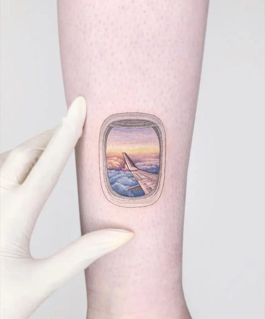 Small Realism Airplane Window with Clouds and Sunset Tattoo on Women Arm by @maya_gat