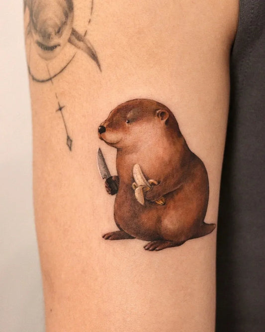 Small Realism Beaver with Knife and Banana Tattoo on Women Arm by @hongzo.tt