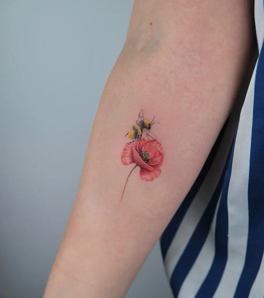 Small Realism Bee and Poppy Tattoo on Women Arm by @mariink.tattoos