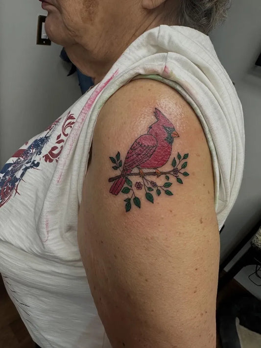 Small Realism Cardinal Branch Tattoo on Women Shoulder by @rebelrosetattoo