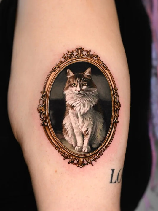 Small Realism Cat in Ornate Frame Tattoo on Women Arm by @dm.tatts