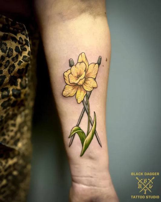 Small Realism Daffodil With Chopsticks Tattoo on Women Arm by @blackdaggertattoonorwich
