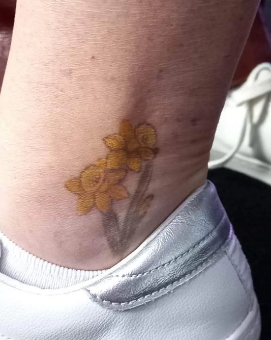 Small Realism Daffodils Tattoo on Women Ankle by @elyskenttattoo