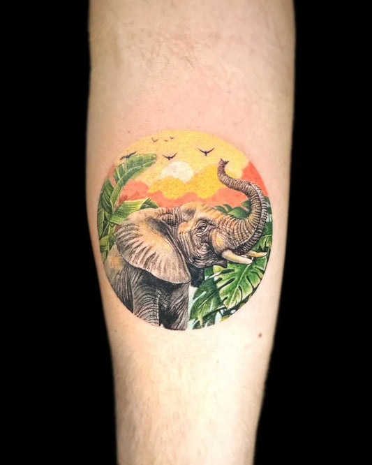 Small Realism Elephant with Sunset and Palm Leaves Tattoo on Men Arm by @alldaytattoobkk