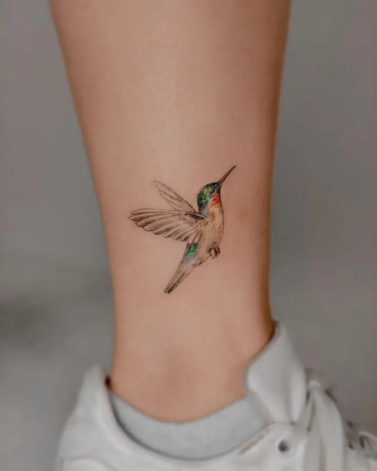 Small Realism Hummingbird Tattoo on Women Ankle by @dongtattoostudio