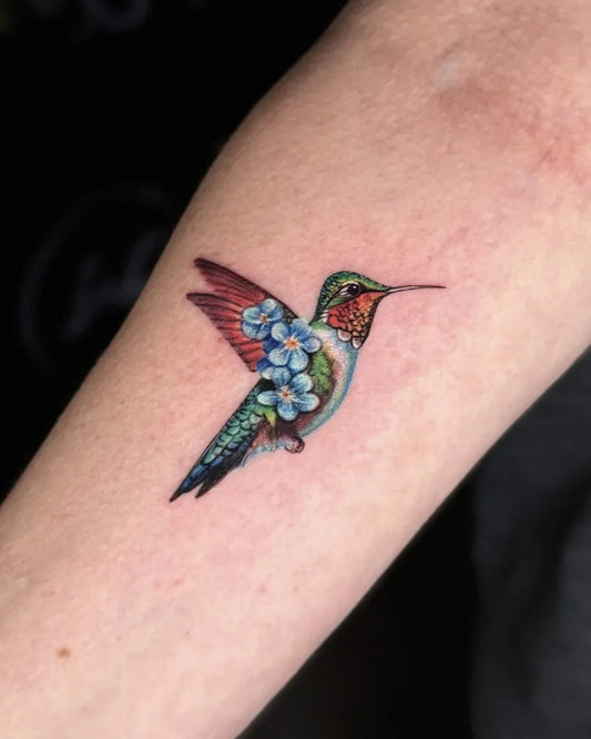 Small Realism Hummingbird with Flowers on Women Arm Tattoo by @mr.inkwells
