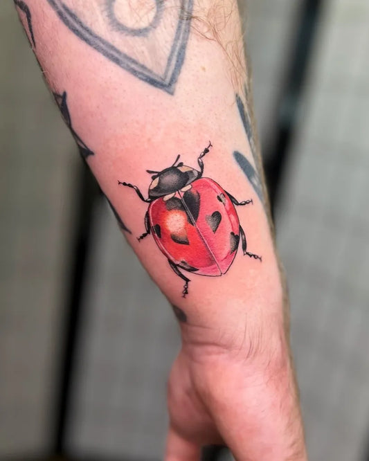 Small Realism Ladybug Tattoo on Men Arm by @skoll_tattoo