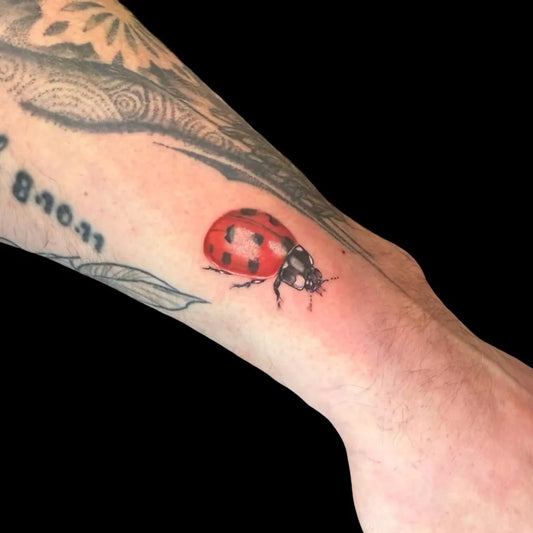 Small Realism Ladybug Tattoo on Men Arm by @vik_tat2