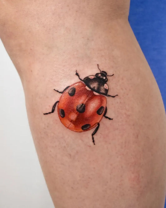 Small Realism Ladybug Tattoo on Women Thigh by @laurence.t.l