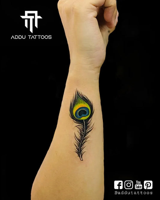Small Realism Peacock Feather Tattoo on Women Wrist by @addu_tattooz_nagpur