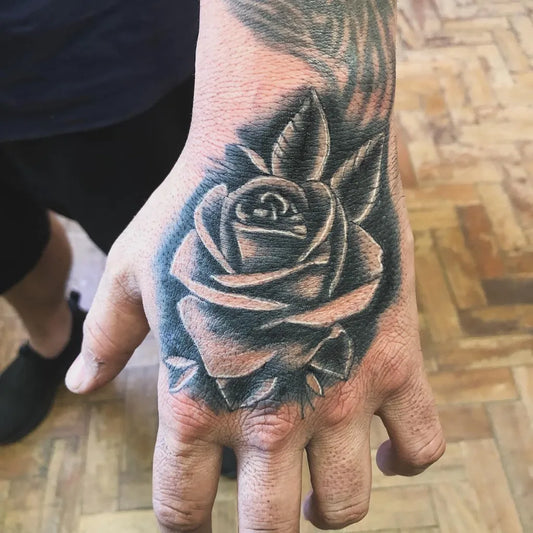 Small Realism Rose on Men Hand Tattoo by @fernando_jr_tattoo