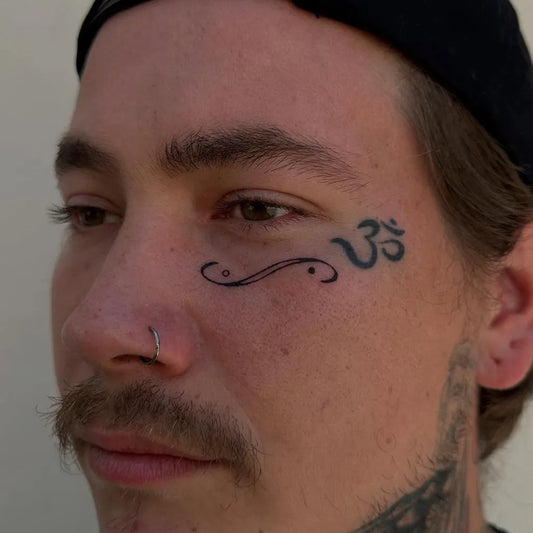 Small Realistic Om Symbol on Men Face Tattoo by @yoette.xo