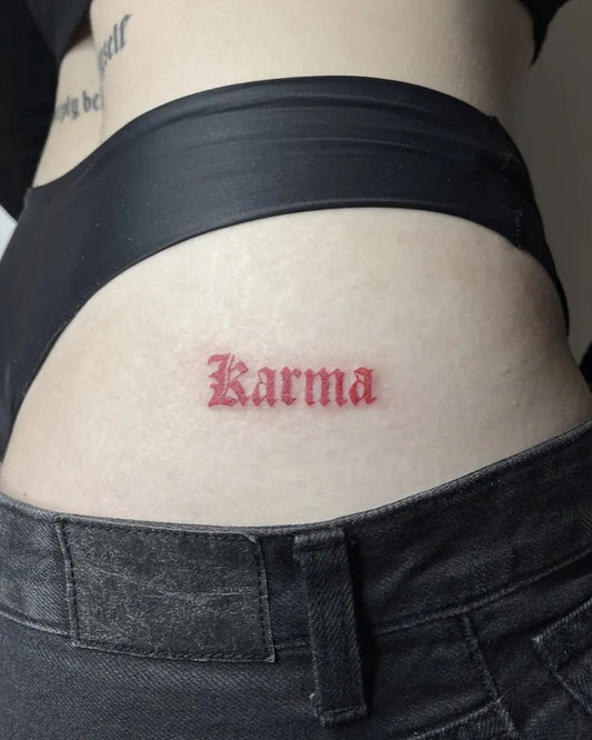 Small Red Karma Word Tattoo on Women Hip by @storm.si