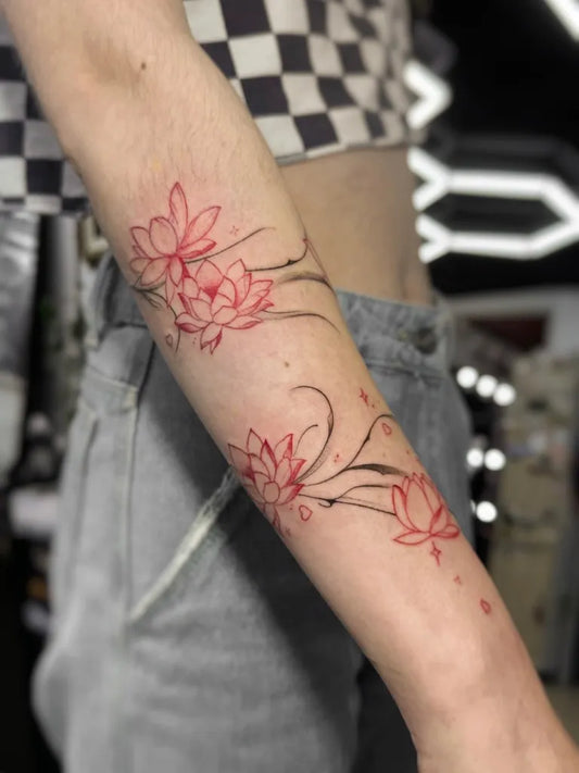 Small Red Lotus Flowers Tattoo on Women Arm by @dariz.ink