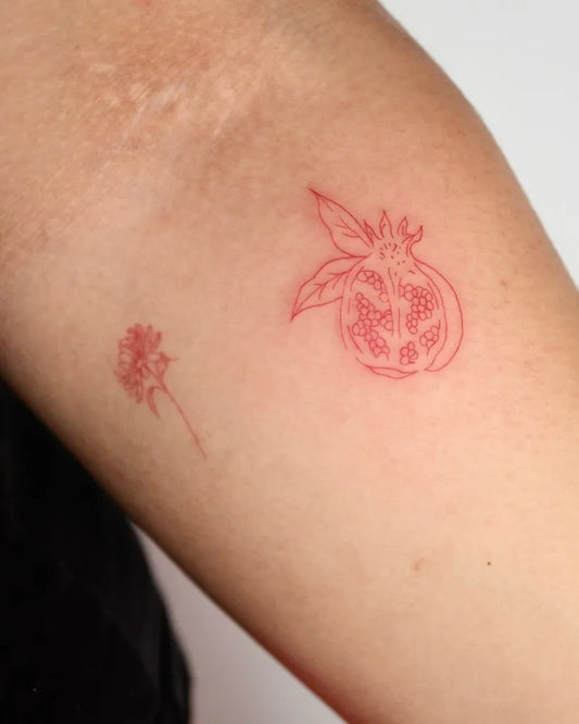 Small Red Pomegranate and Flower Tattoo on Women Arm by @namitatts