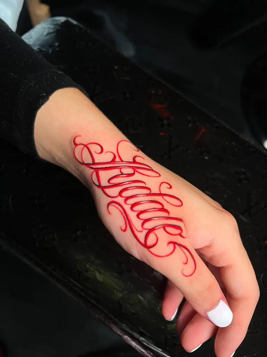 Small Red Script Name Tattoo on Women Wrist by @stillballin6_