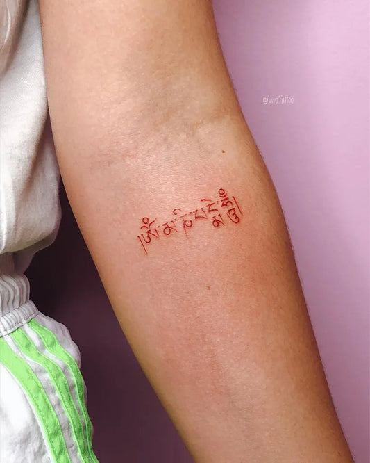 Small Red Tibetan Script Tattoo on Women Forearm by @vivotattoo