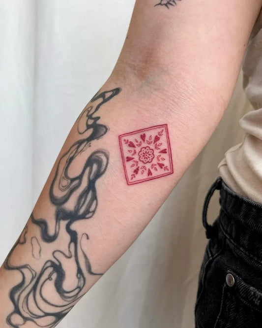 Small Red Tile Tattoo on Women Arm by @pelc.tt