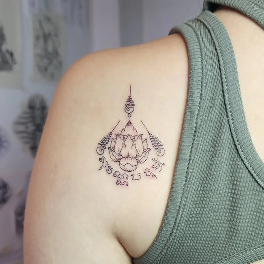 Small Sak Yant Lotus Script Tattoo on Women Shoulder by @nomoreinktattoo