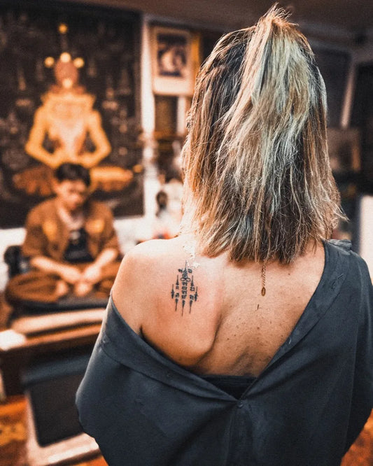 Small Sak Yant Yant Script Tattoo on Women Shoulder by @arjannengthaisakyant