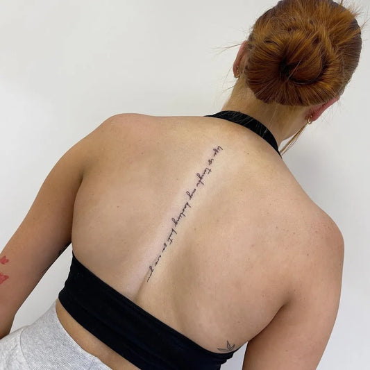 Small Script Arabic Text on Women Spine Tattoo by @dr.inkkk