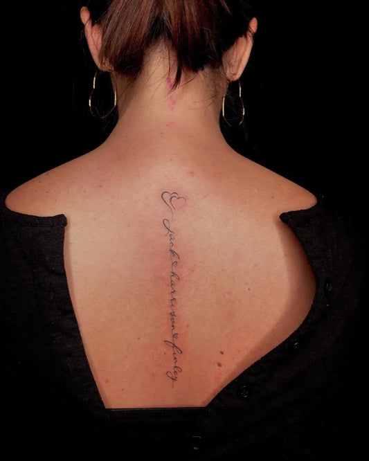 Small Script Arabic script on Women Spine Tattoo by @lilygrace.ink