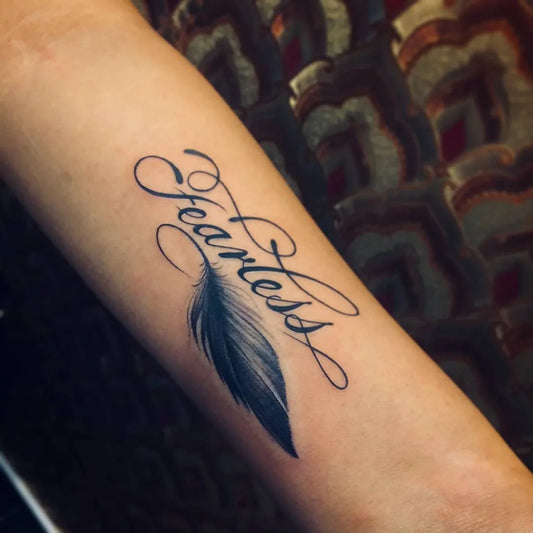 Small Script Feather Tattoo on Women Arm by @nick.tattooist