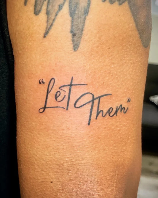 Small Script Let Them on Men Arm Tattoo by @thinkpr_tattoo