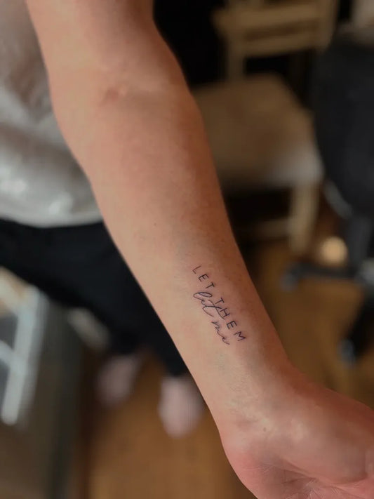 Small Script Let Them on Women Arm Tattoo by @wild.brand.co