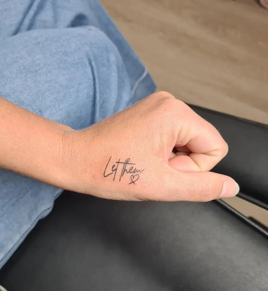 Small Script Let Them on Women Wrist Tattoo by @brow_face_by_danni