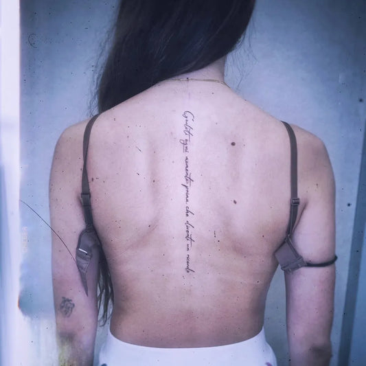 Small Script Quote on Women Spine Tattoo by @andre.omens