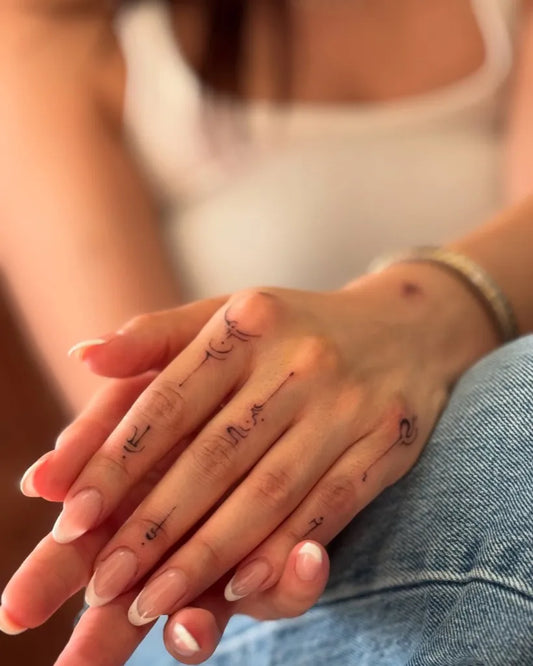 Small Script Symbols on Women Fingers Tattoo by @oznrgnc.ink
