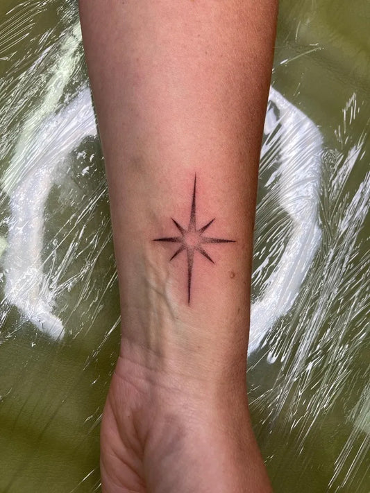 Small Stick and Poke Compass Star Tattoo on Women Wrist by @elphie.quinn