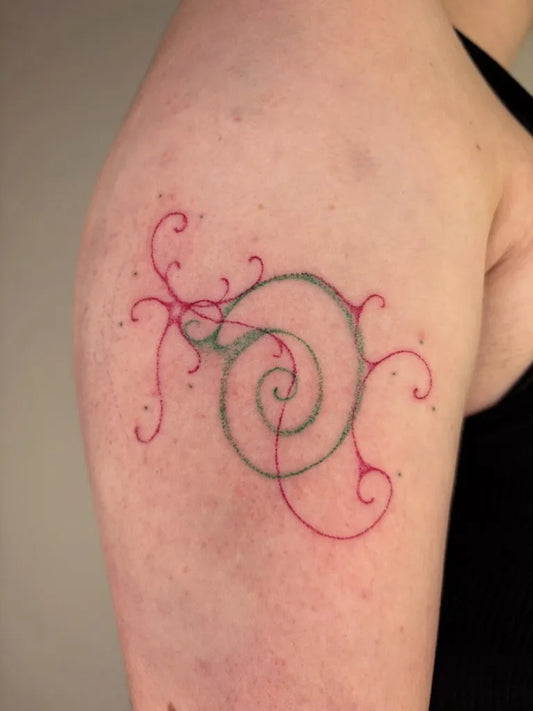 Small Stick and Poke Spiral Shell with Vines Tattoo on Women Upper Arm by @phelipokes