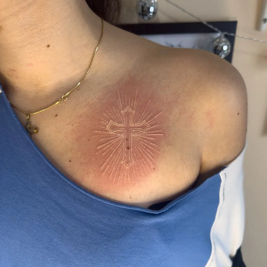 Small Traditional Cross Radiating on Women Shoulder Tattoo by @amberwilliamstattoos