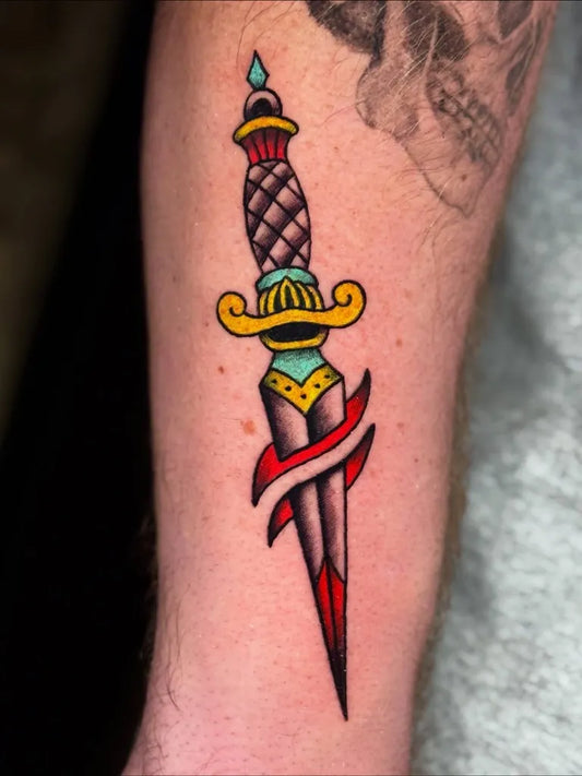 Small Traditional Dagger with Banner Tattoo on Men Arm by @dylancrookstattoos