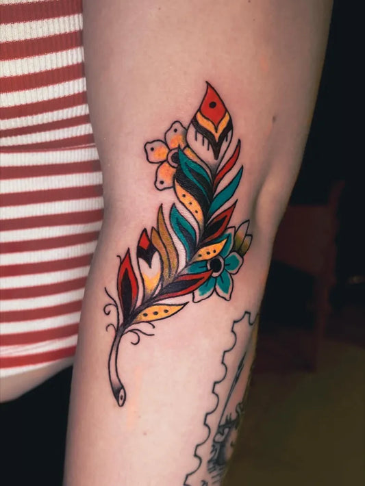 Small Traditional Feather and Flowers Tattoo on Women Arm by @pierogi.tattoos