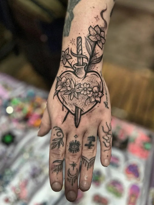 Small Traditional Heart with Dagger and Flowers on Women Hand Tattoo by @samanthanube