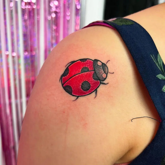 Small Traditional Ladybug Tattoo on Women Shoulder by @oh.emgtattoo