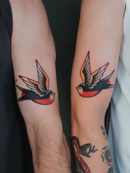Small Traditional Matching Swallow Tattoo on Men Arm by @figtree.tattoo.studio
