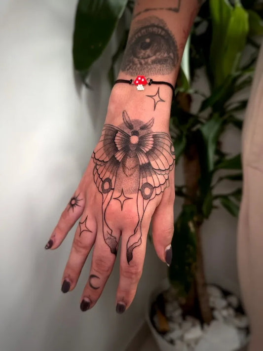 Small Traditional Moth Mushroom on Women Hand Tattoo by @selfish.tattoo