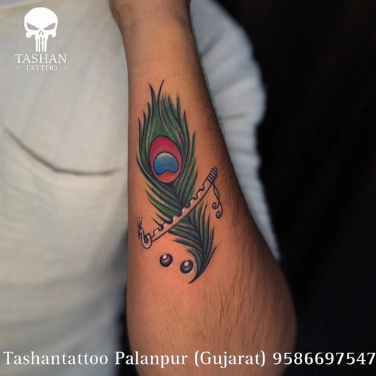 Small Traditional Peacock Feather Flute Tattoo on Men Arm by @ashoktattoowala