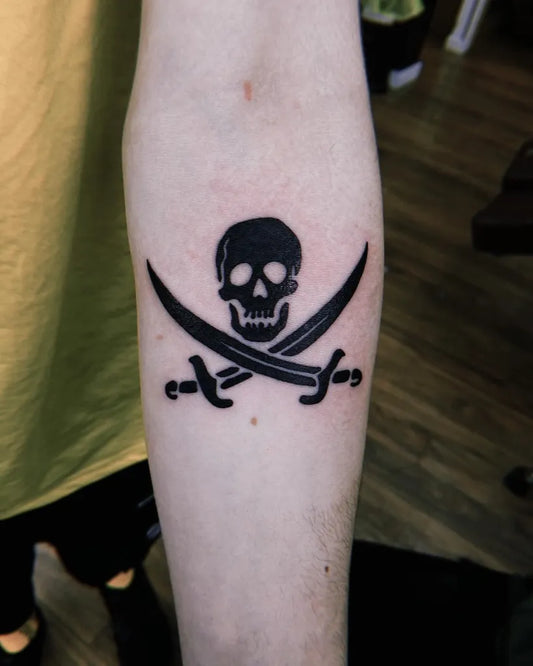 Small Traditional Skull and Crossed Swords on Men Arm Tattoo by @trinny.h.art