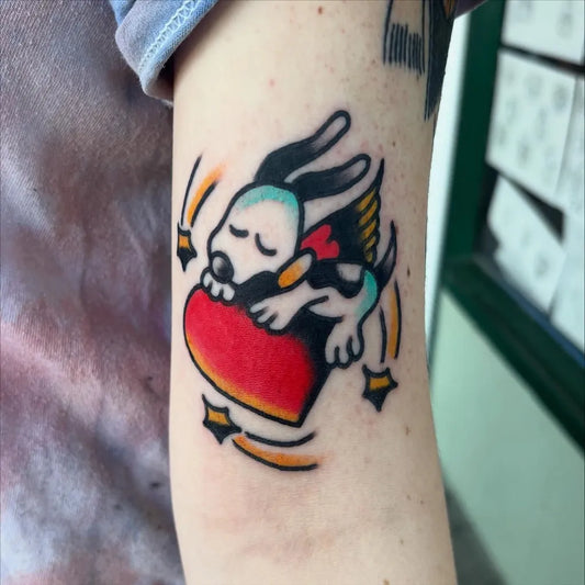 Small Traditional Snoopy with Heart and Wings Tattoo on Women Arm by @mrcizdog