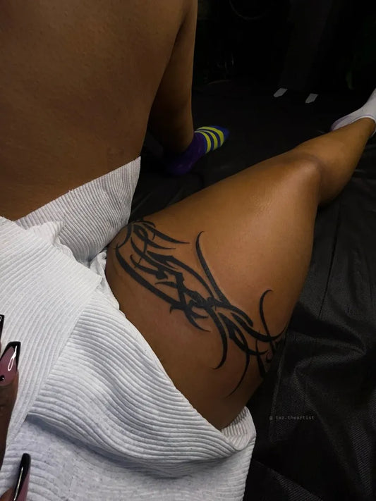 Small Tribal Band on Women Thigh Tattoo by @taztheartist.tattoos