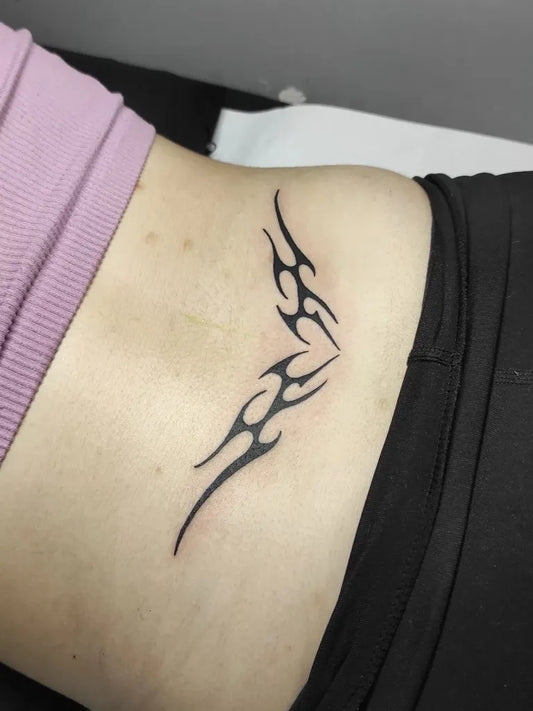 Small Tribal Tribal Flames on Women Back Tattoo by @elenahellraiser_bodyart