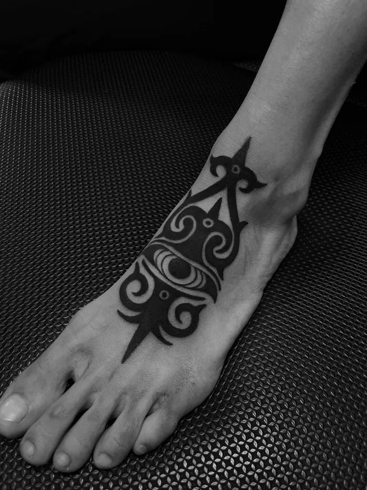 Small Tribal Tribal Motif with Eye Symbol on Women Foot Tattoo by @gamera.om